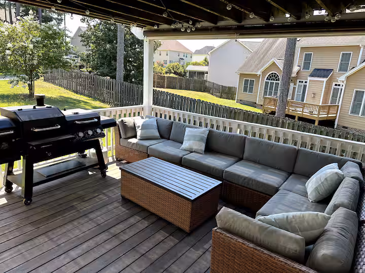 Covered outdoor deck with sectional seating and grill