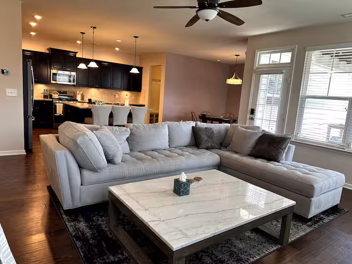 Open living room with large sectional and chef's kitchen beyond